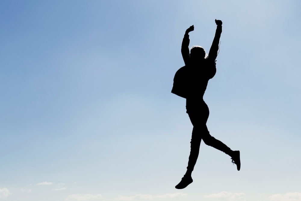 silhouette of man jumping during daytime