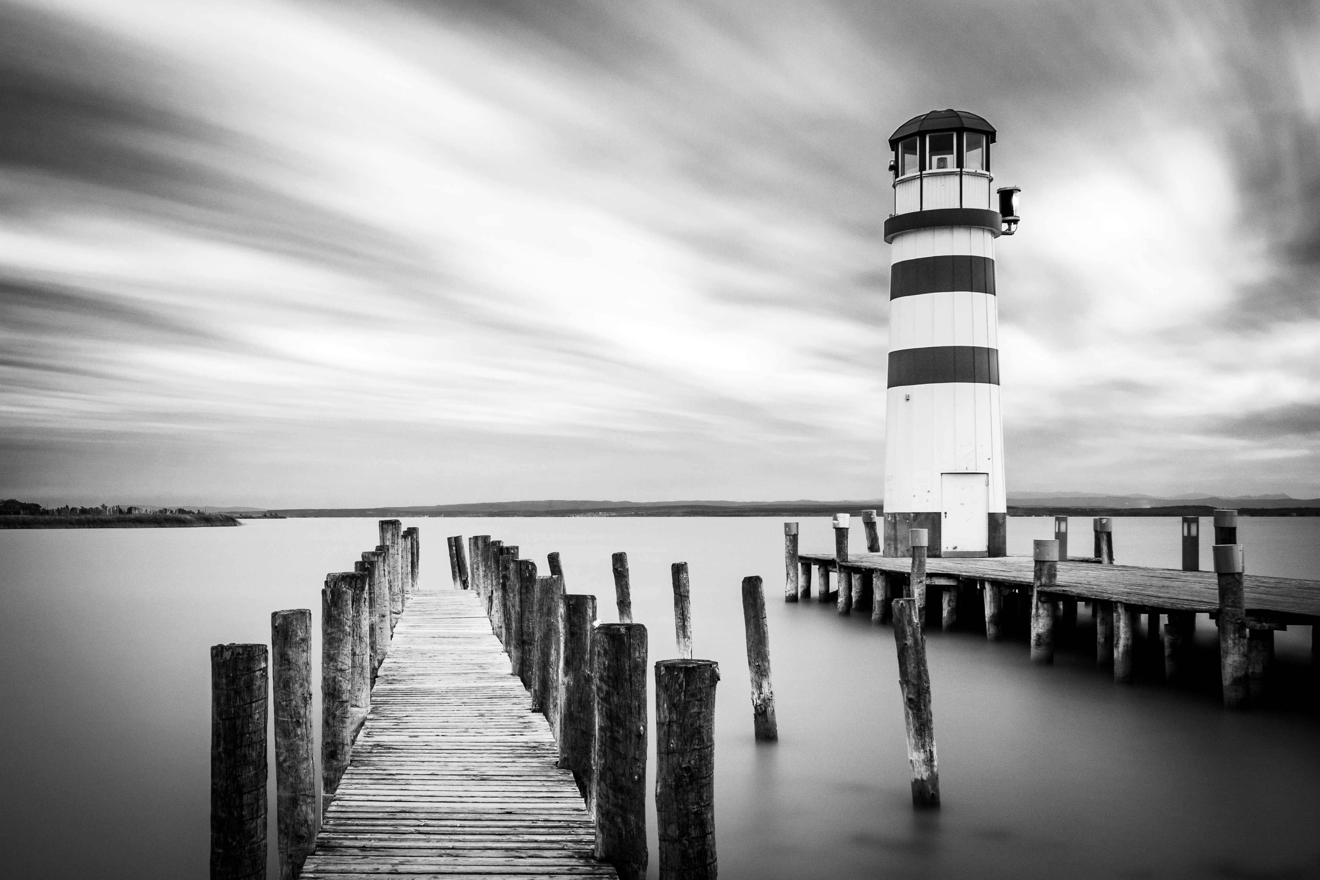 white and black lighthouse near body of water