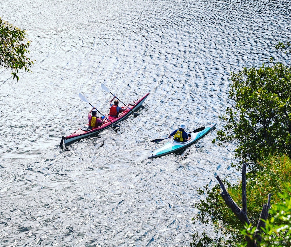 people riding on blue kayak on body of water during daytime
