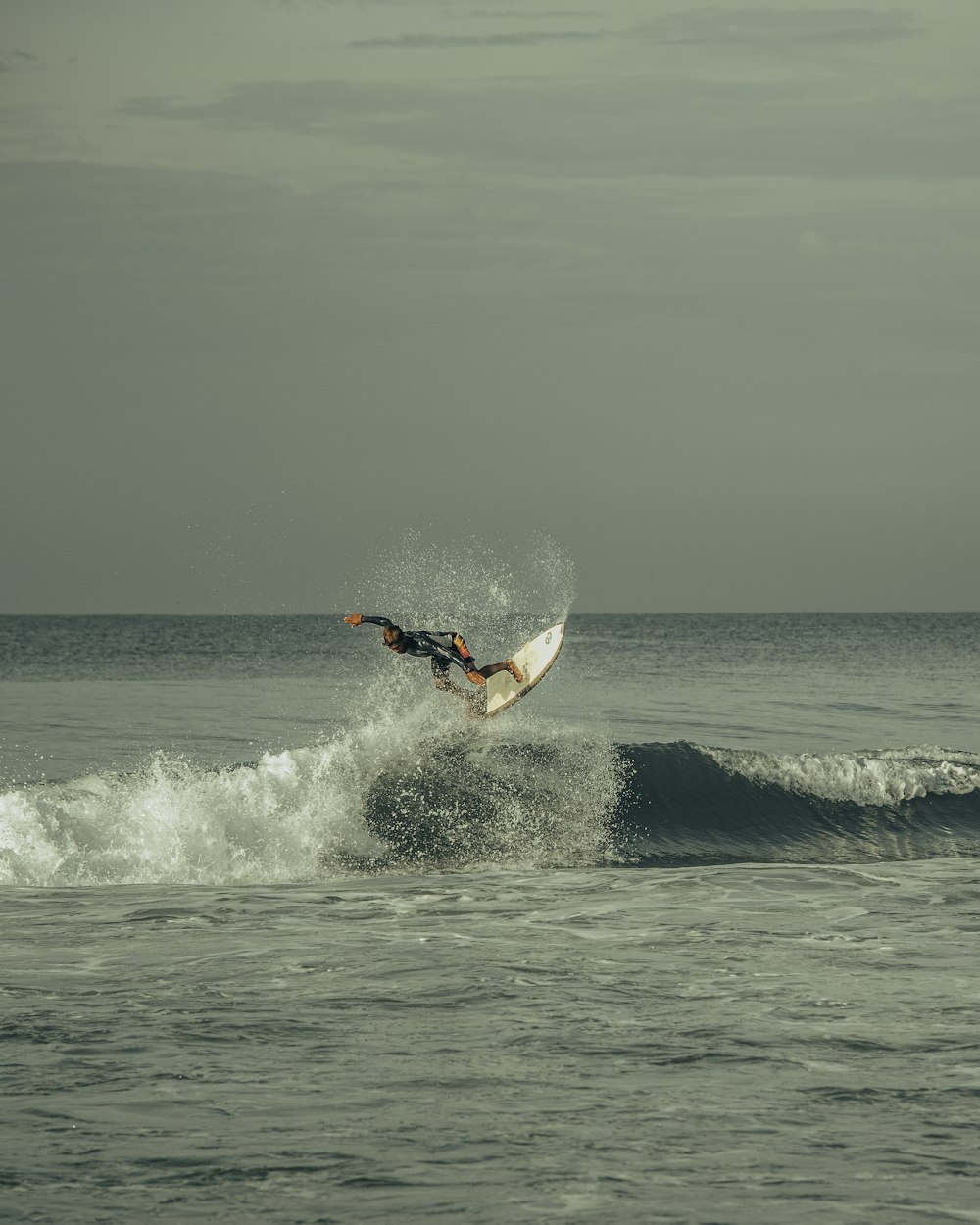 man surfing on sea waves during daytime