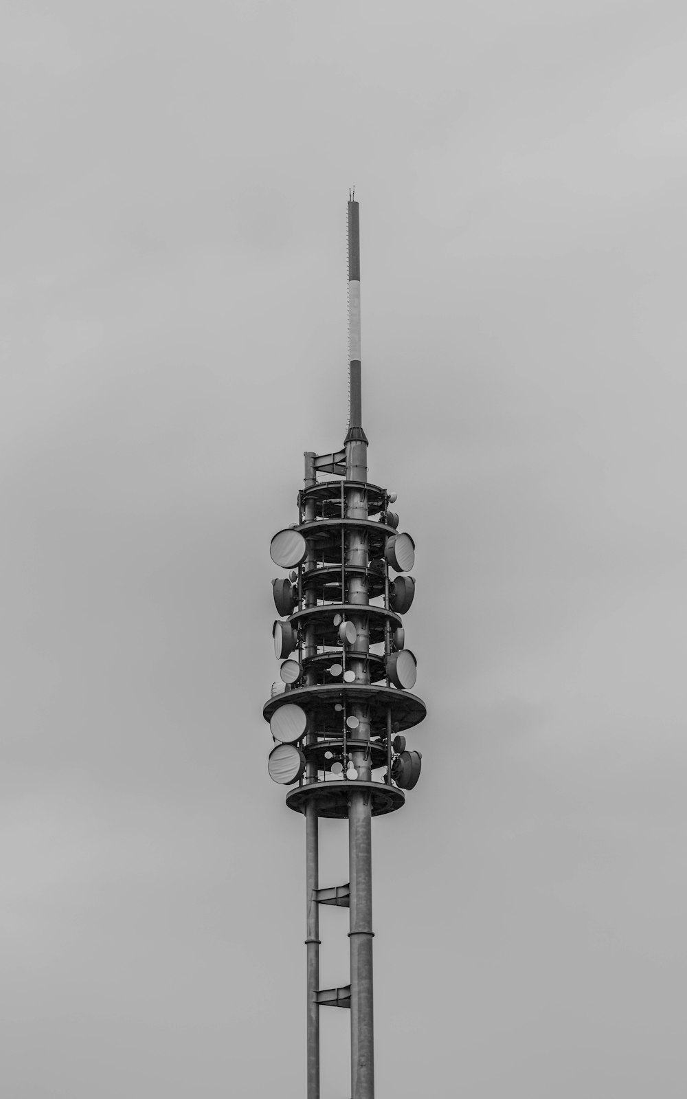 grayscale photo of tower with round metal