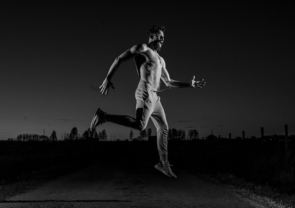 man in white pants jumping on field