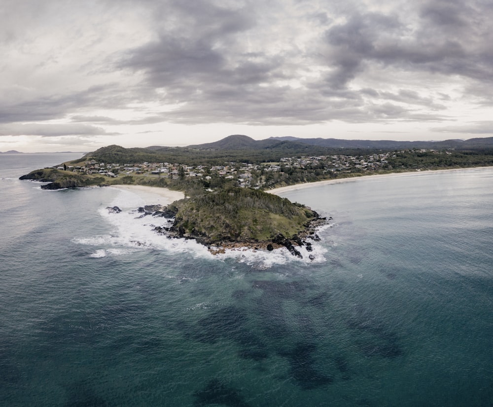 green and brown island under gray clouds