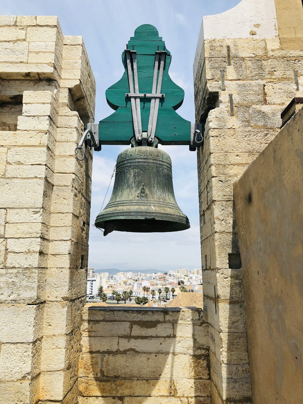 cloche verte sur mur de briques brunes