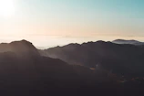 A serene mountain landscape with soft morning light casting gentle shadows.