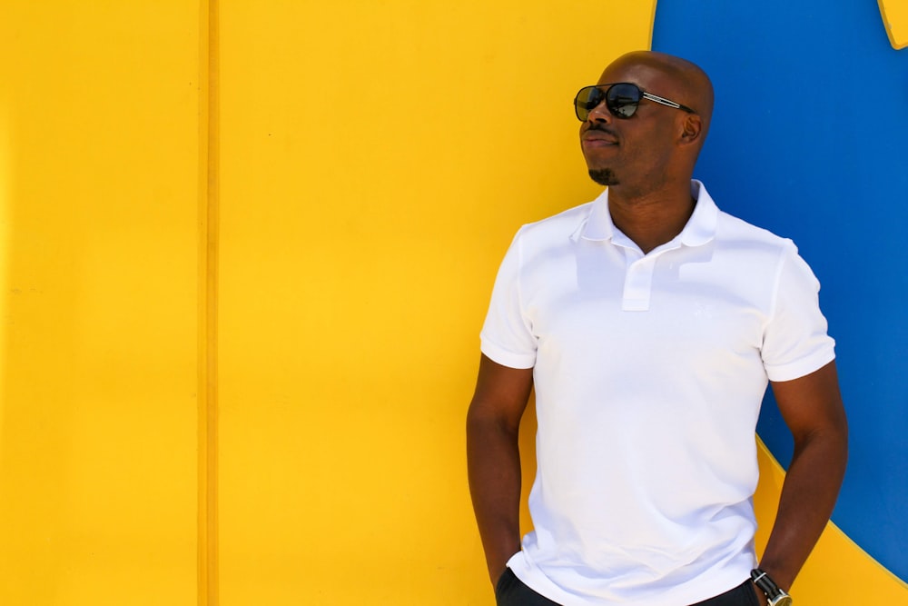 man in white polo shirt wearing blue sunglasses