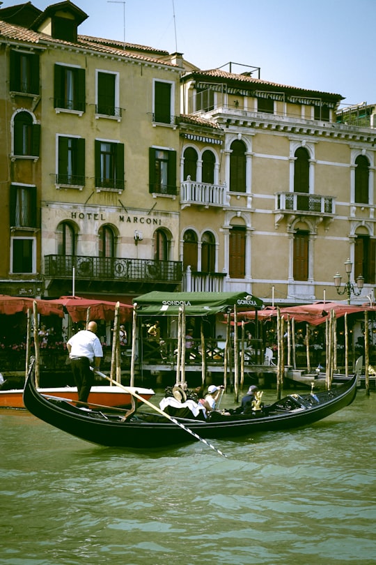 people riding on boat on river near building during daytime in Venice Italy