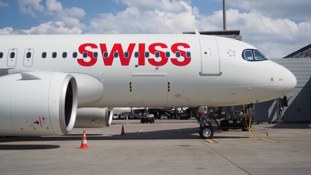 white and red passenger plane on airport during daytime