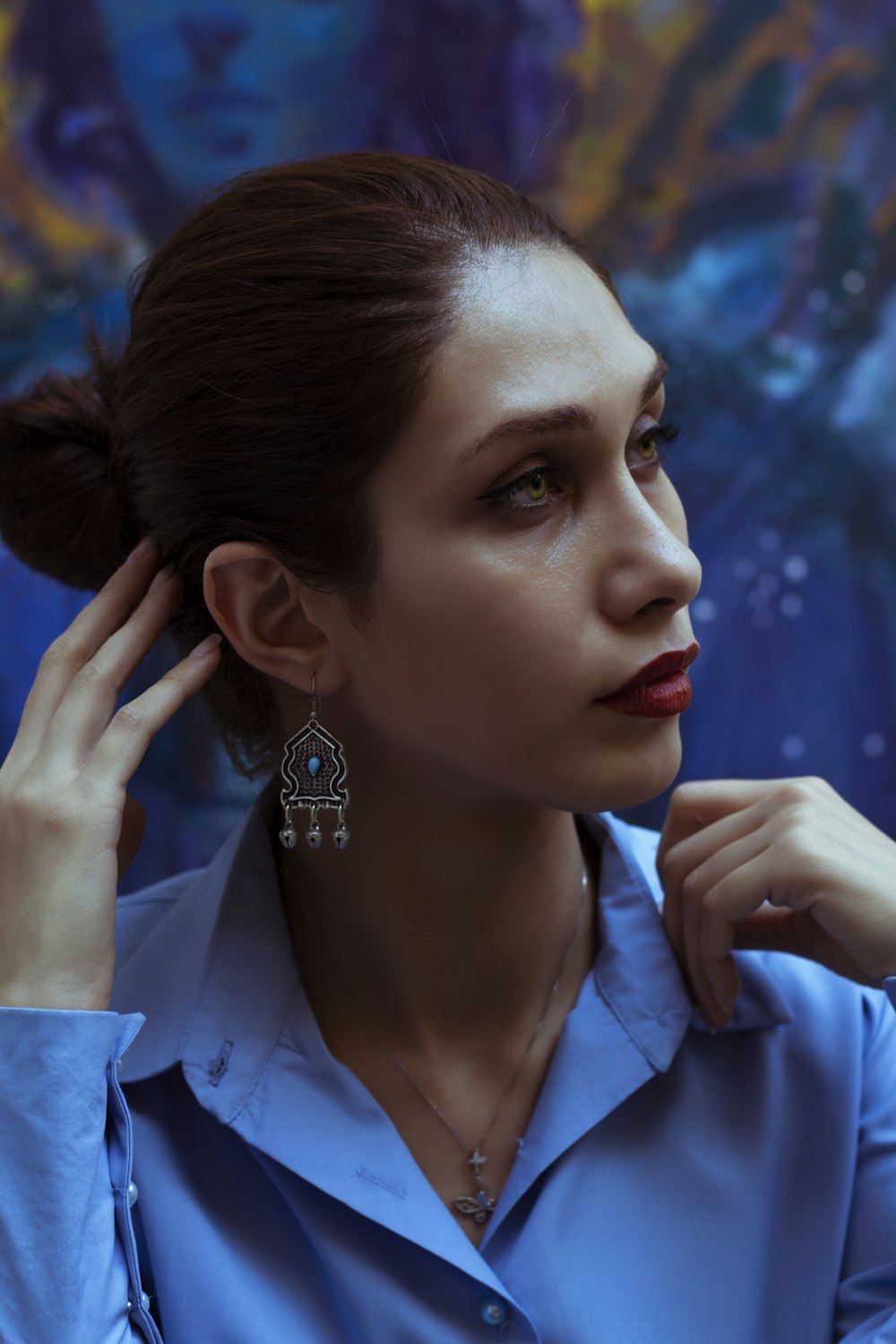 woman in blue collared shirt wearing silver earrings