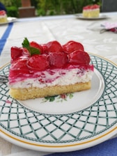 Close-up of a beautifully decorated artisanal cake with fresh fruits on a rustic wooden table.