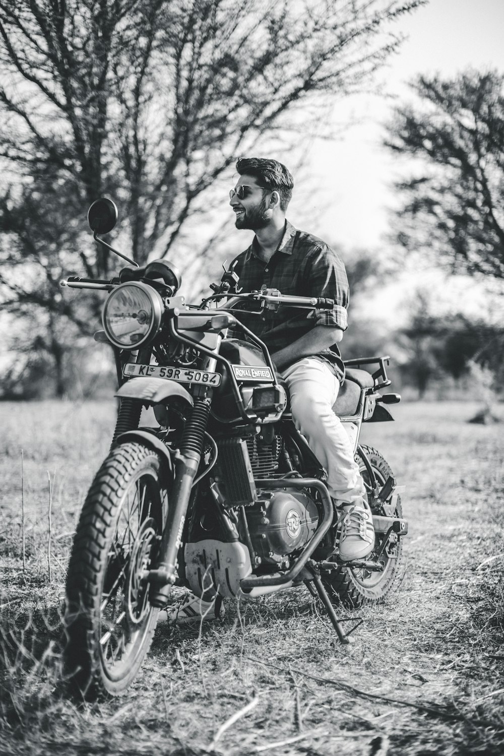 grayscale photo of man riding motorcycle