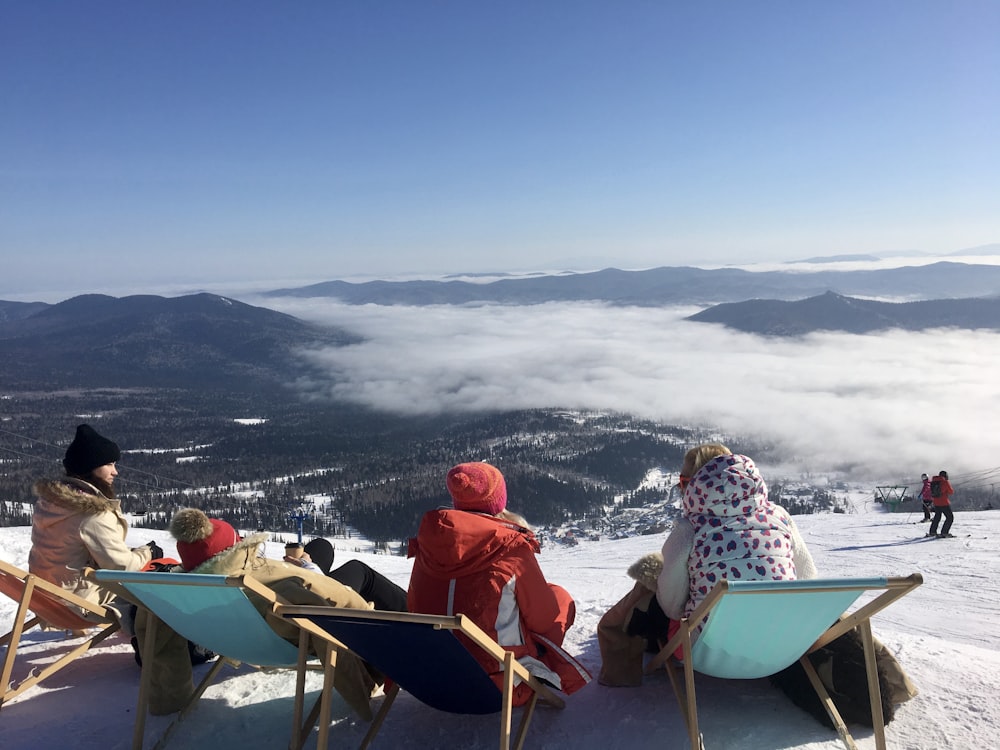 2 person sitting on chair on snow covered ground during daytime