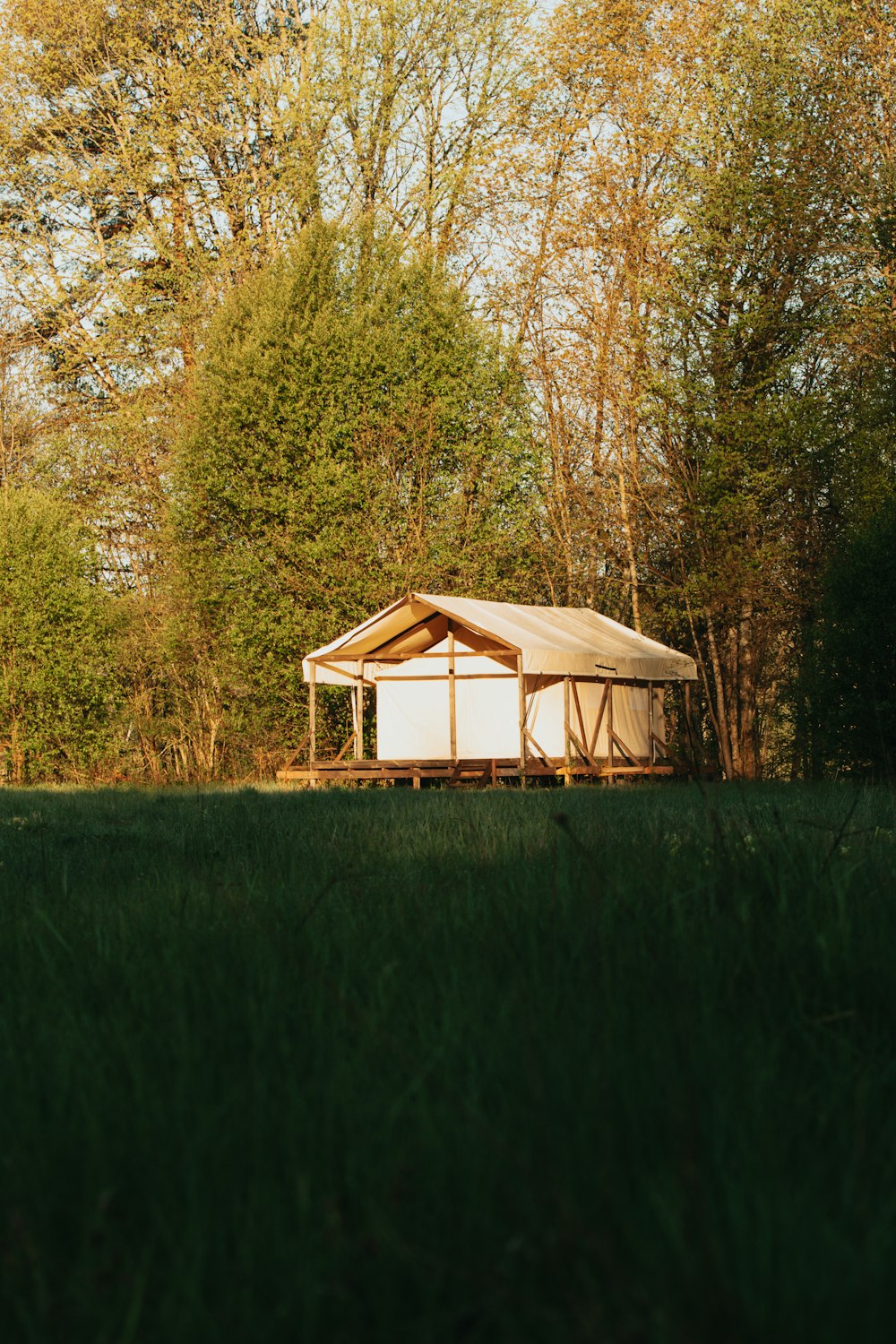 white and brown tent on green grass field during daytime