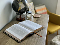opened book on brown wooden table