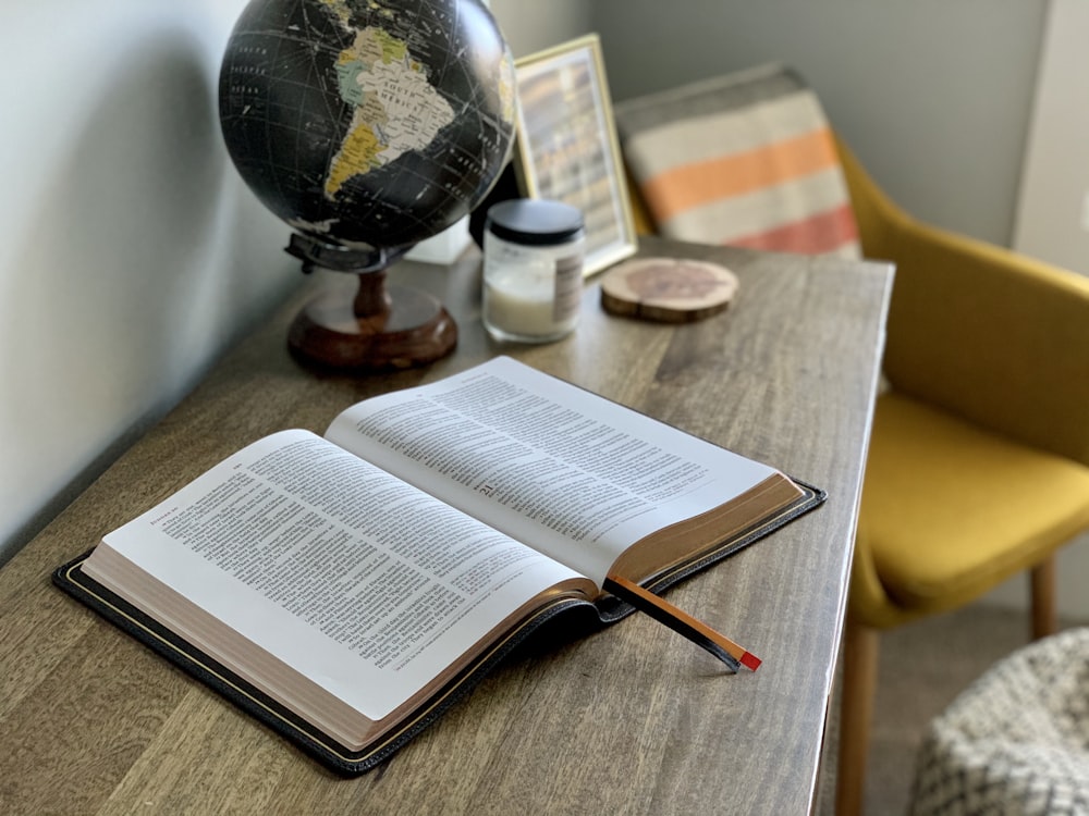 opened book on brown wooden table