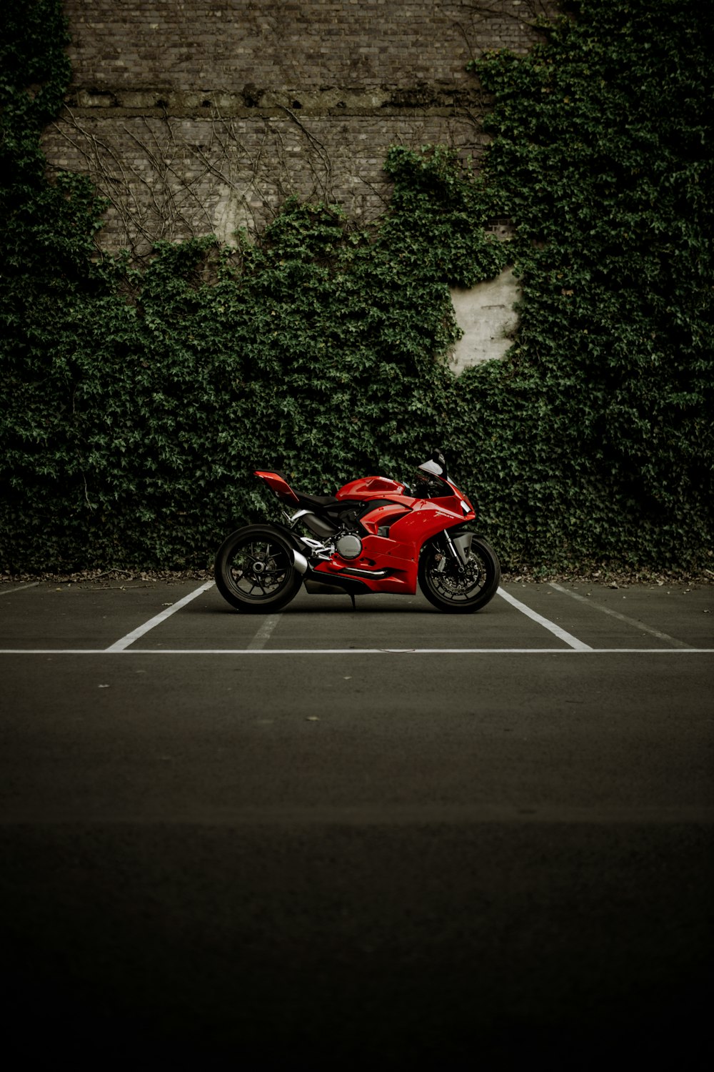 red and black sports bike parked on gray concrete road