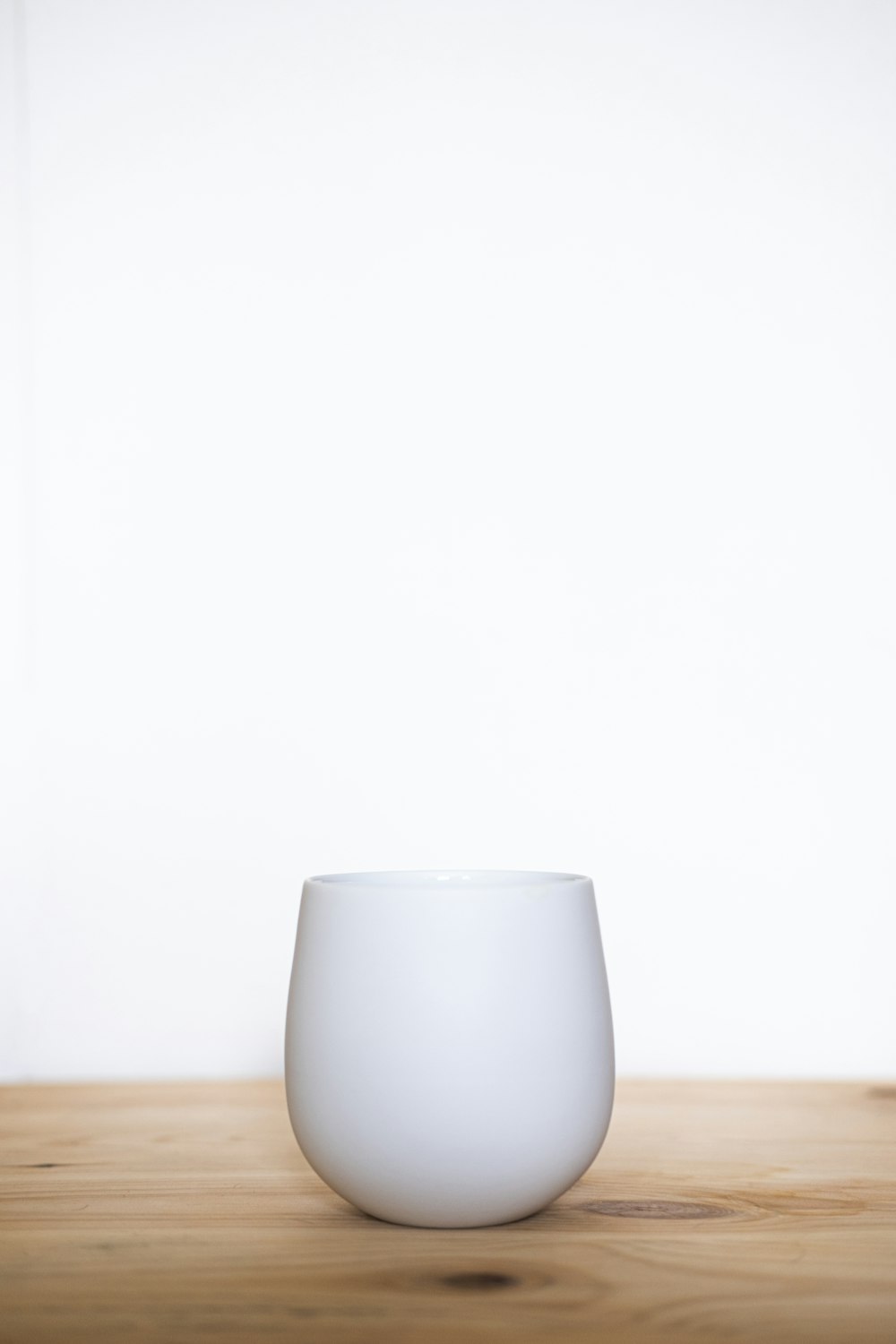 white ceramic mug on brown wooden table