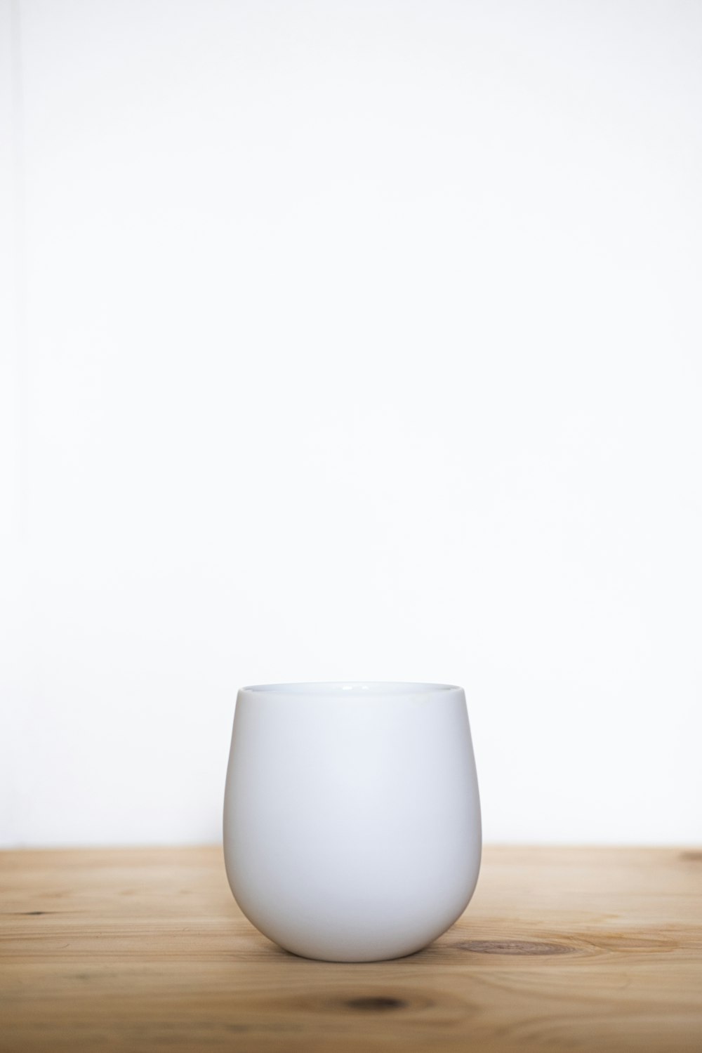 Taza de cerámica blanca sobre mesa de madera marrón