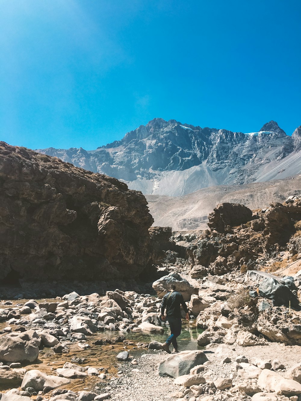 Mann in grüner Jacke und schwarzer Hose, der tagsüber auf dem Rocky Mountain steht