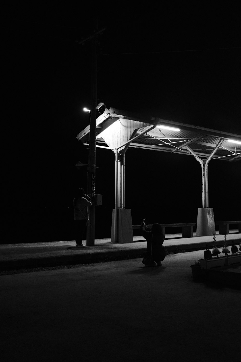 a black and white photo of a person sitting on a bench