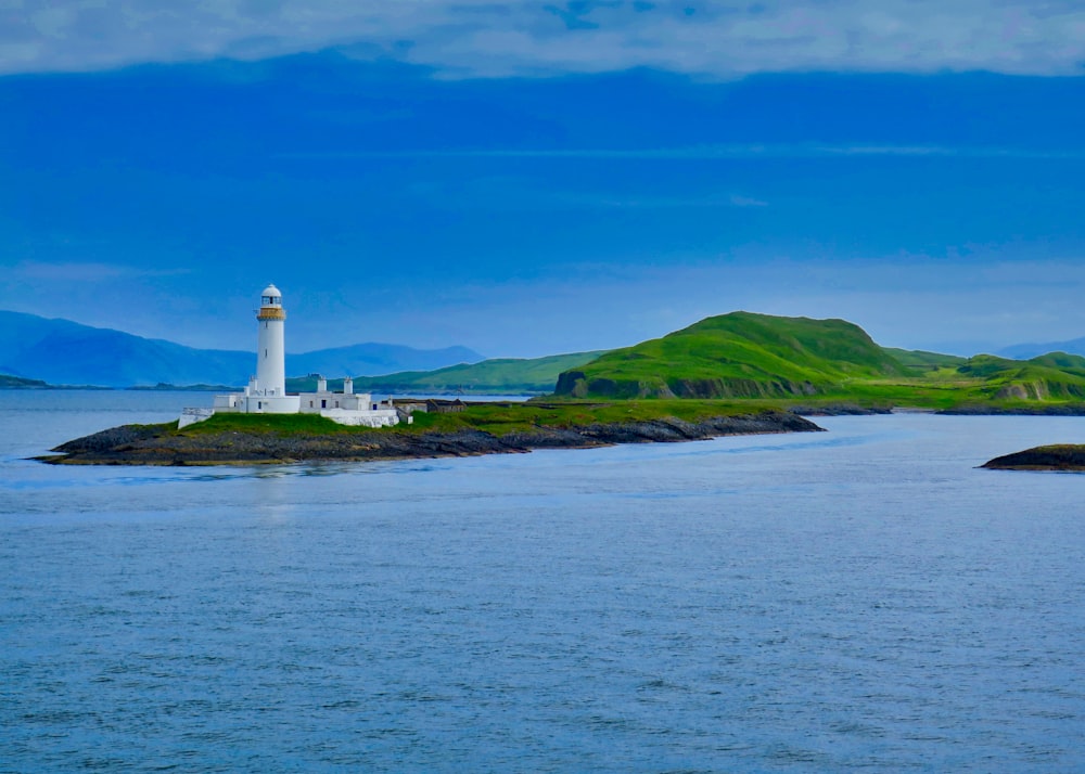 white lighthouse on green grass field under blue sky during daytime