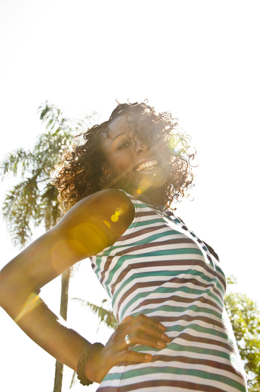 woman in white and black stripe shirt holding yellow plastic bottle