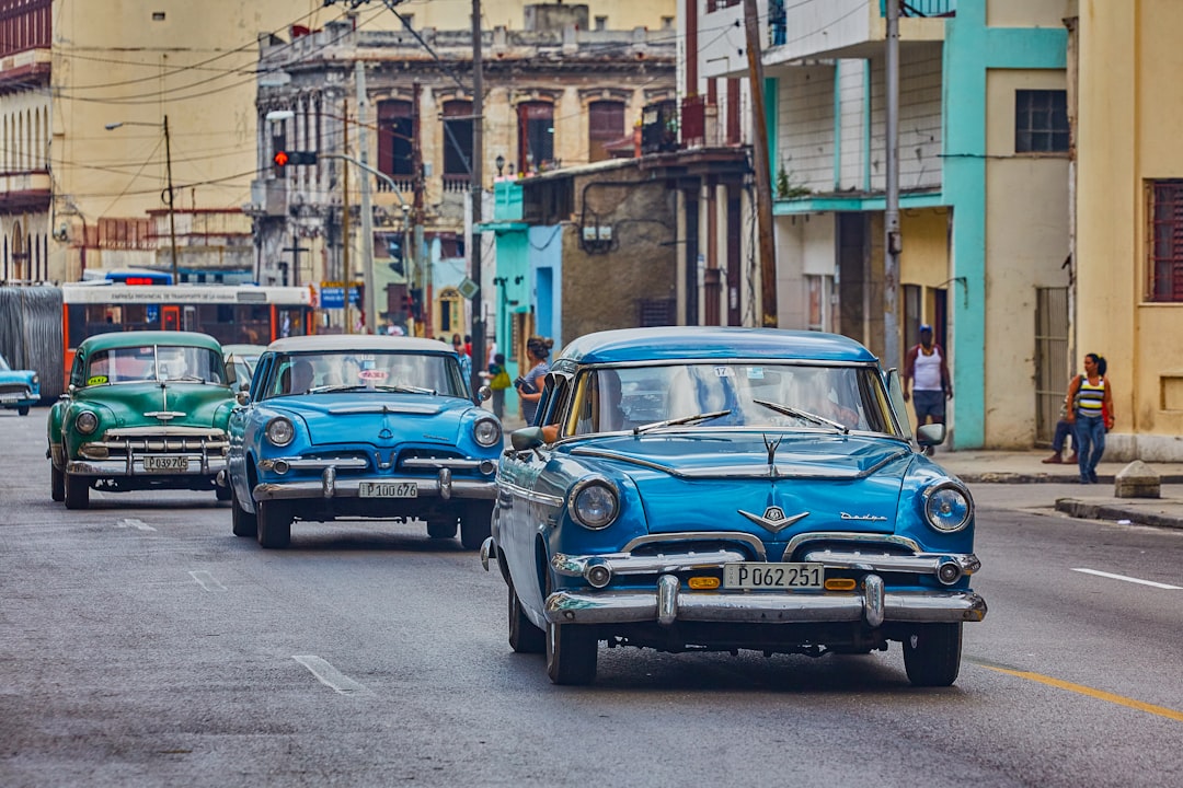 blue classic car parked on sidewalk during daytime