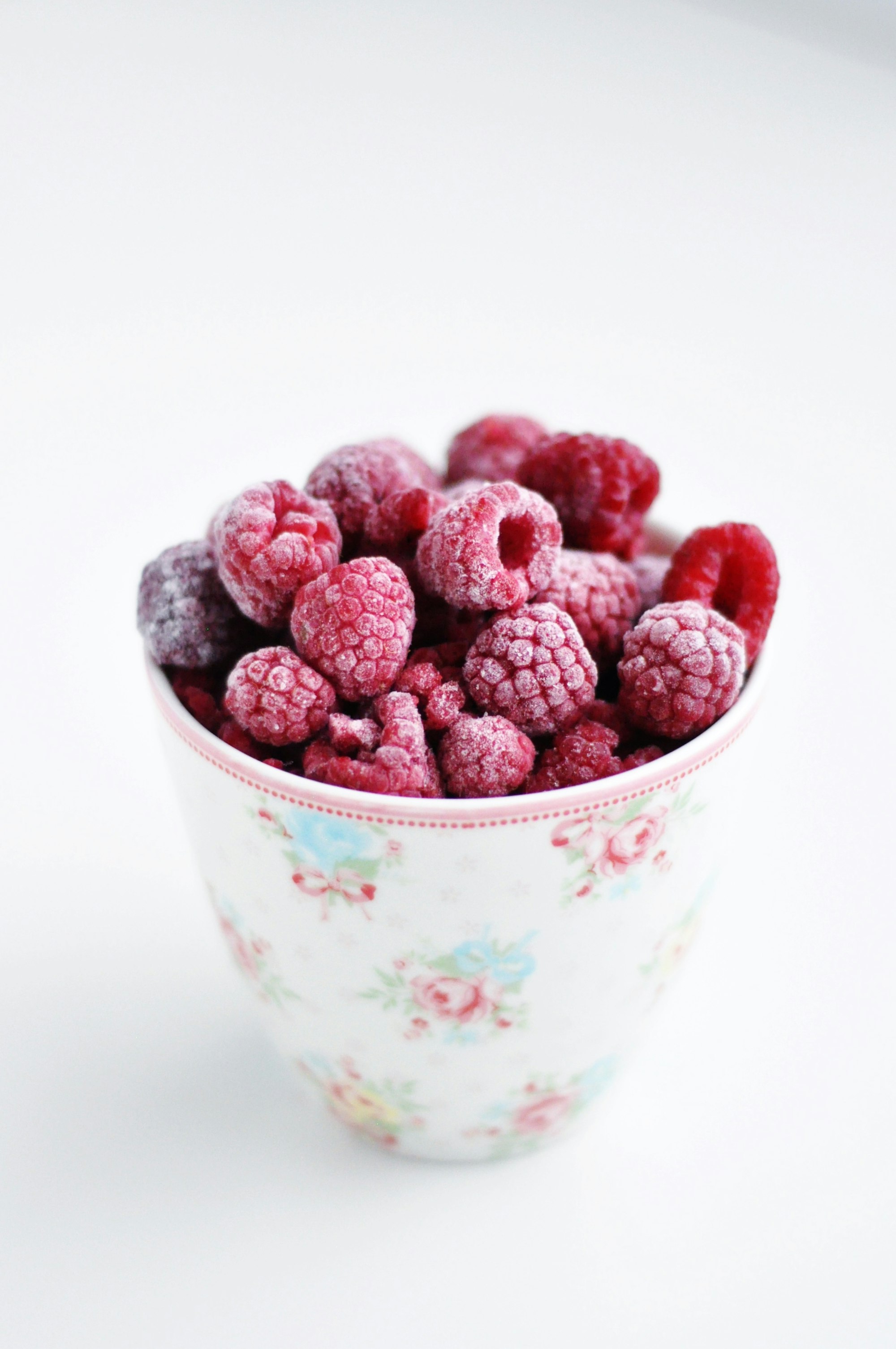 A bowl filled with frozen raspberries symbolizing the concept of freezing eggs for fertility preservation.