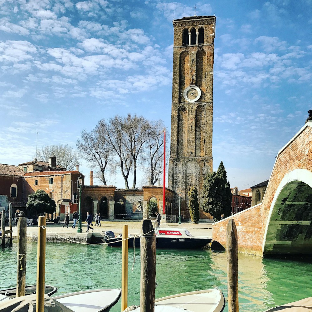 Edificio in cemento marrone vicino allo specchio d'acqua sotto il cielo blu durante il giorno