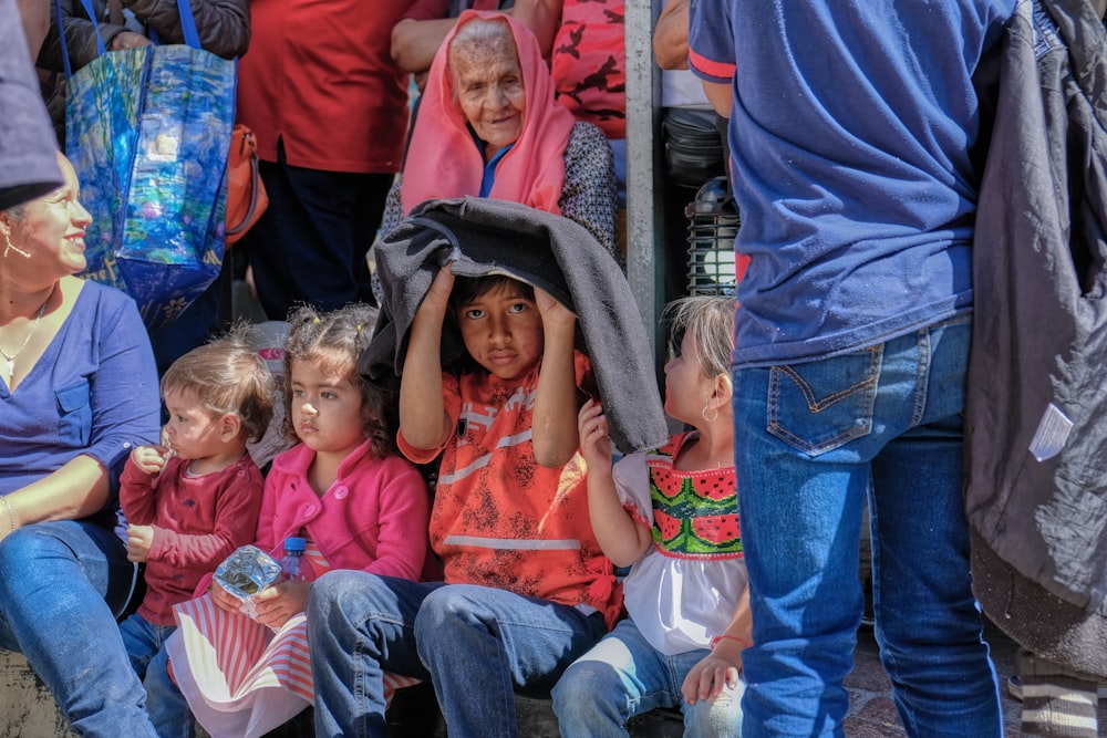 woman in blue hijab carrying girl in pink shirt