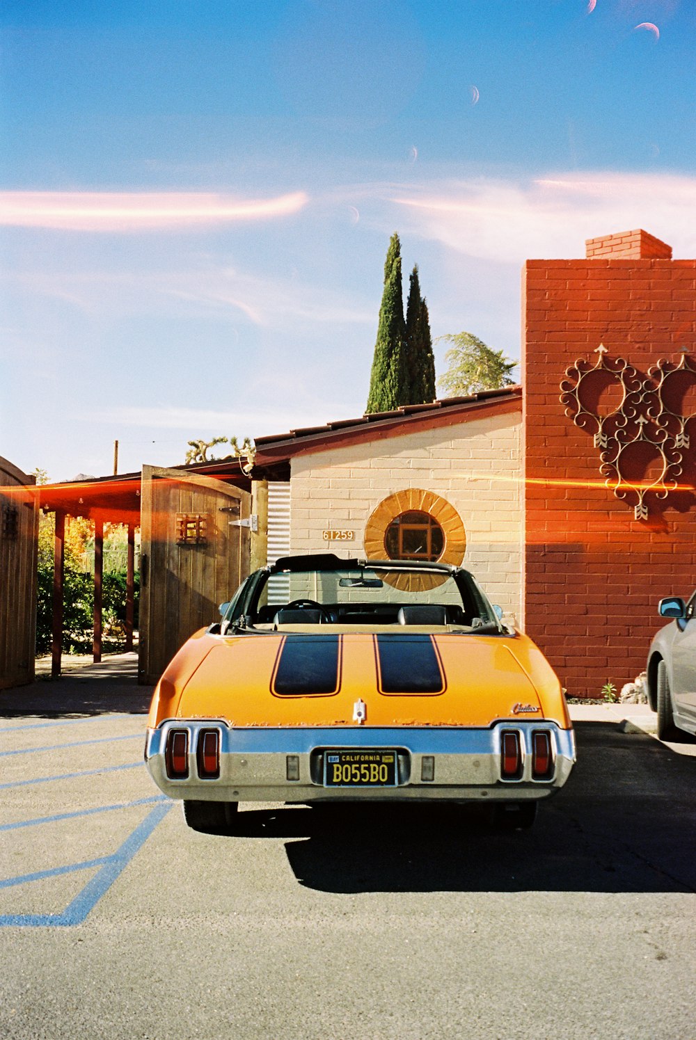 blue car parked beside brown concrete building during daytime