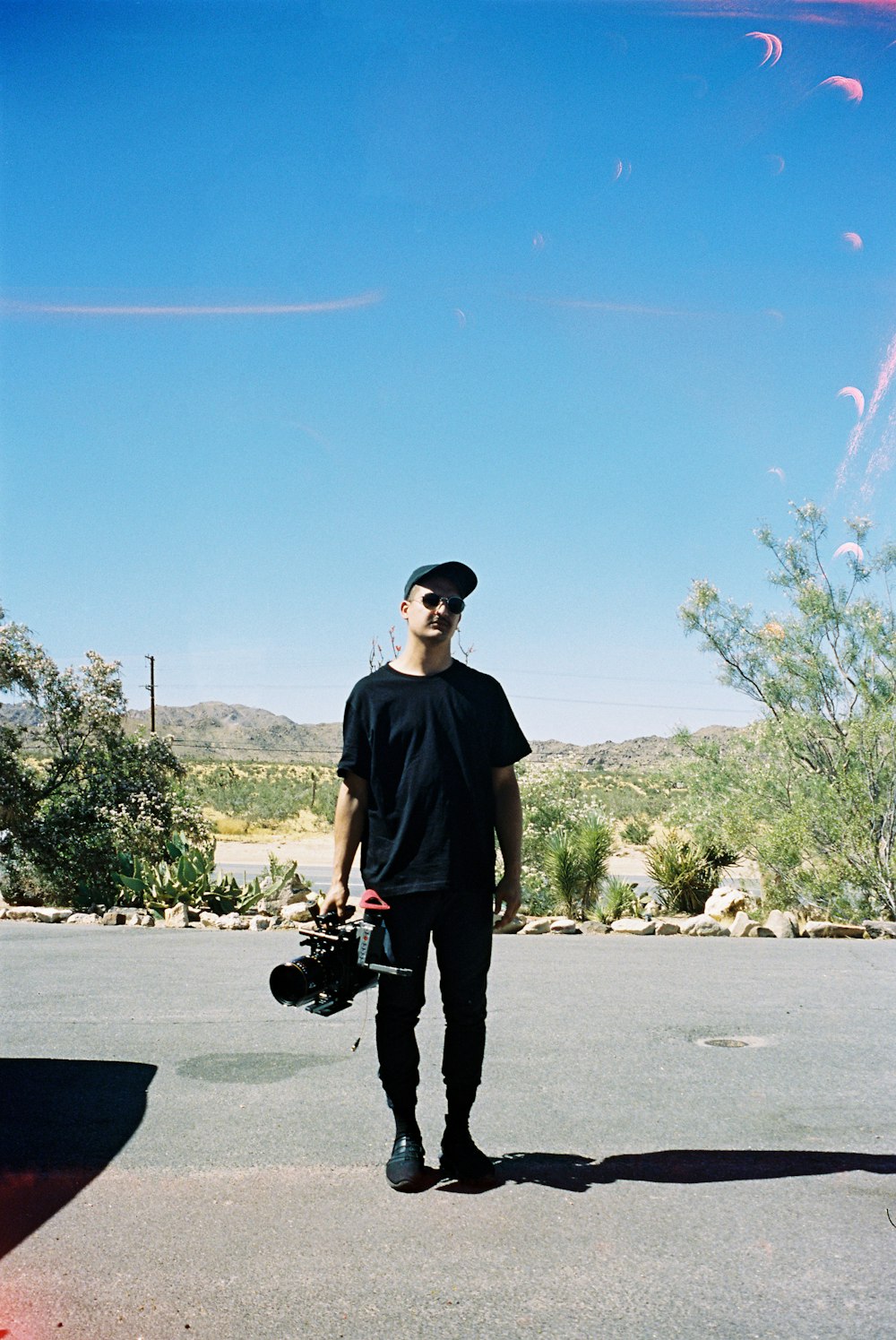 man in black crew neck t-shirt and black pants standing on gray concrete road during