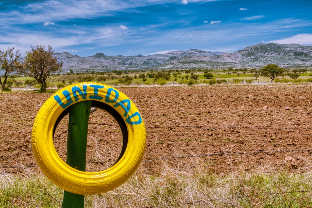 barra metálica redonda amarilla y verde en un campo de hierba marrón durante el día