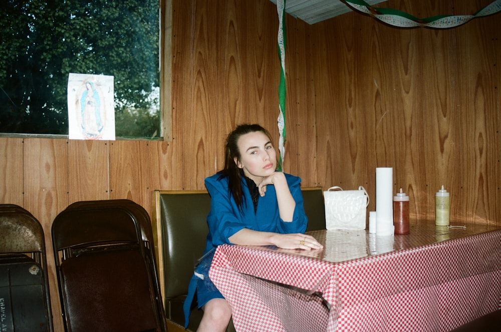 woman in blue long sleeve shirt sitting on black leather chair