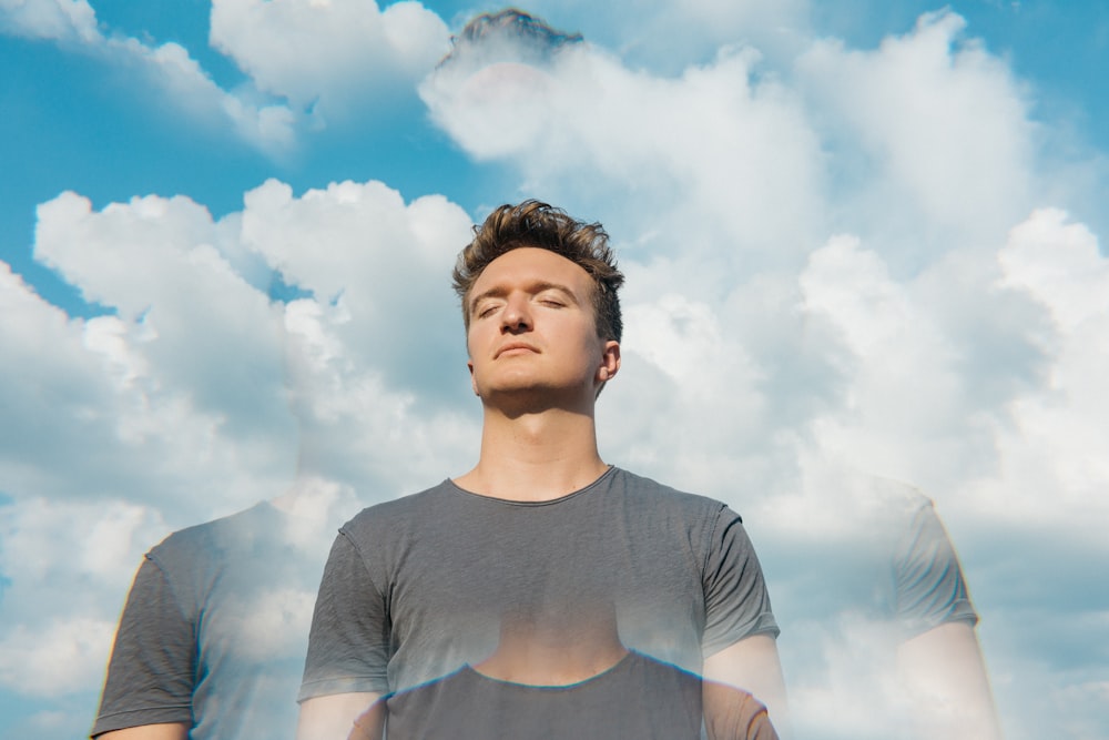 man in gray crew neck t-shirt under white clouds and blue sky during daytime