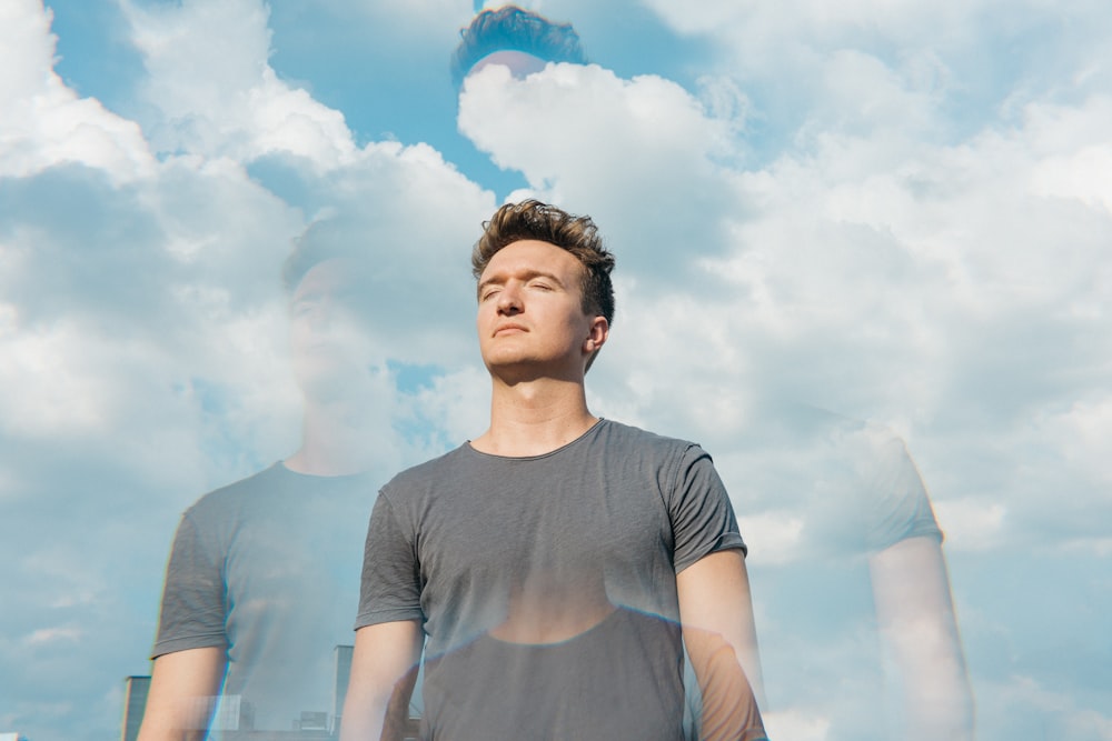 man in gray crew neck t-shirt under white clouds and blue sky during daytime