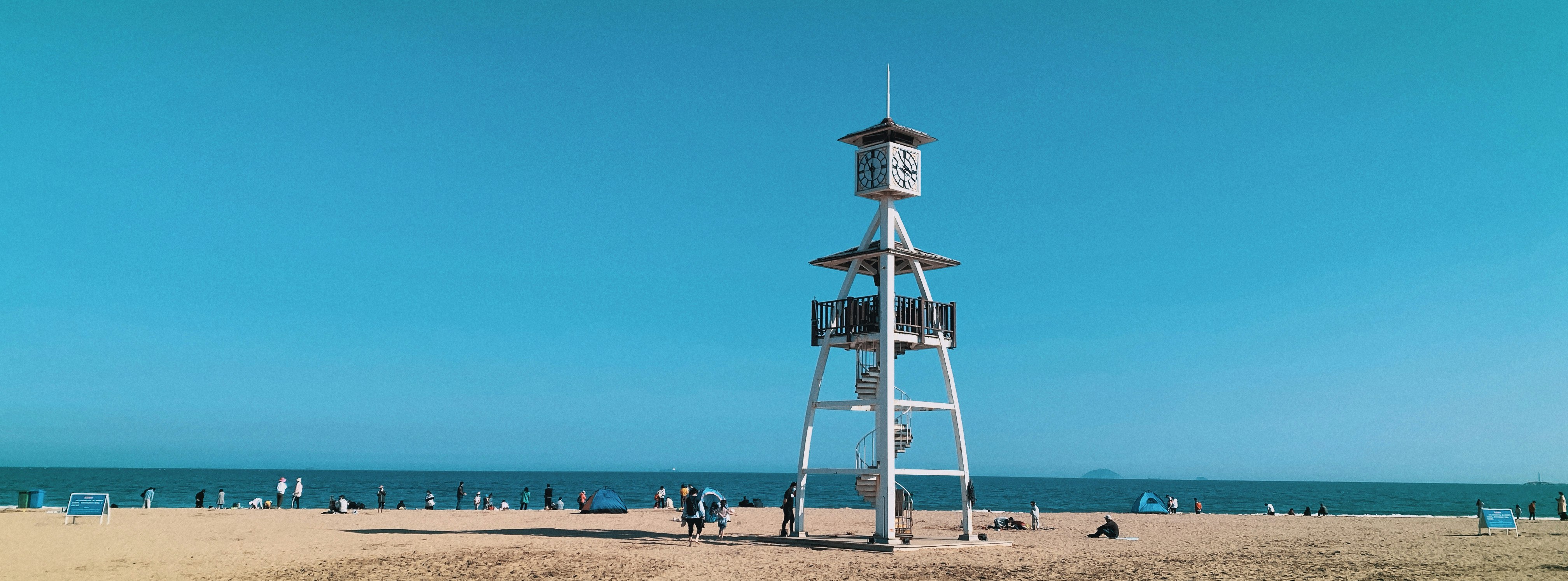 white and brown wooden lifeguard tower on beach during daytime