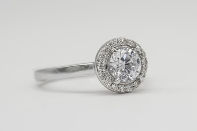 silver diamond studded ring on white surface