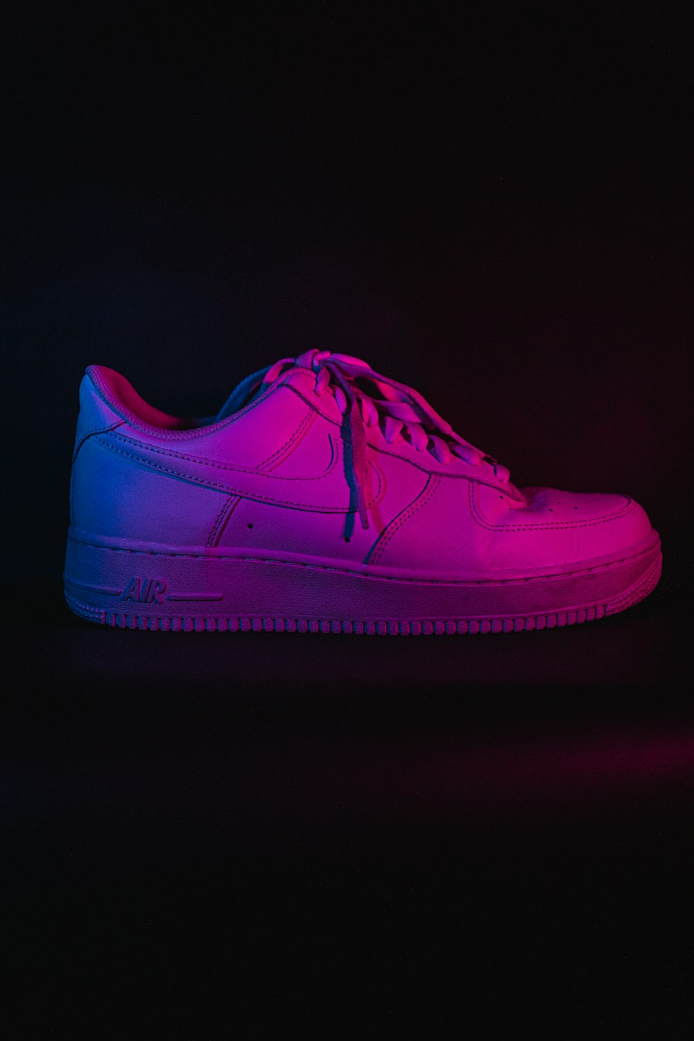 pink nike athletic shoe on white surface