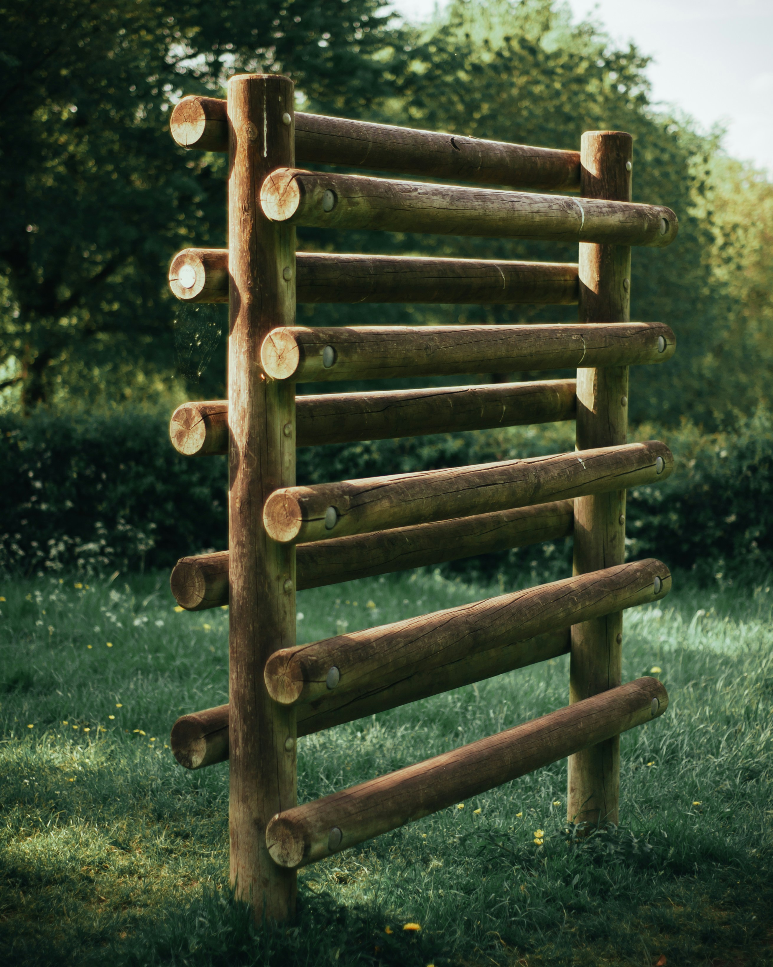 clôture en bois marron sur un champ d’herbe verte pendant la journée