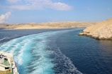body of water near brown sand under blue sky during daytime