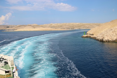 body of water near brown sand under blue sky during daytime