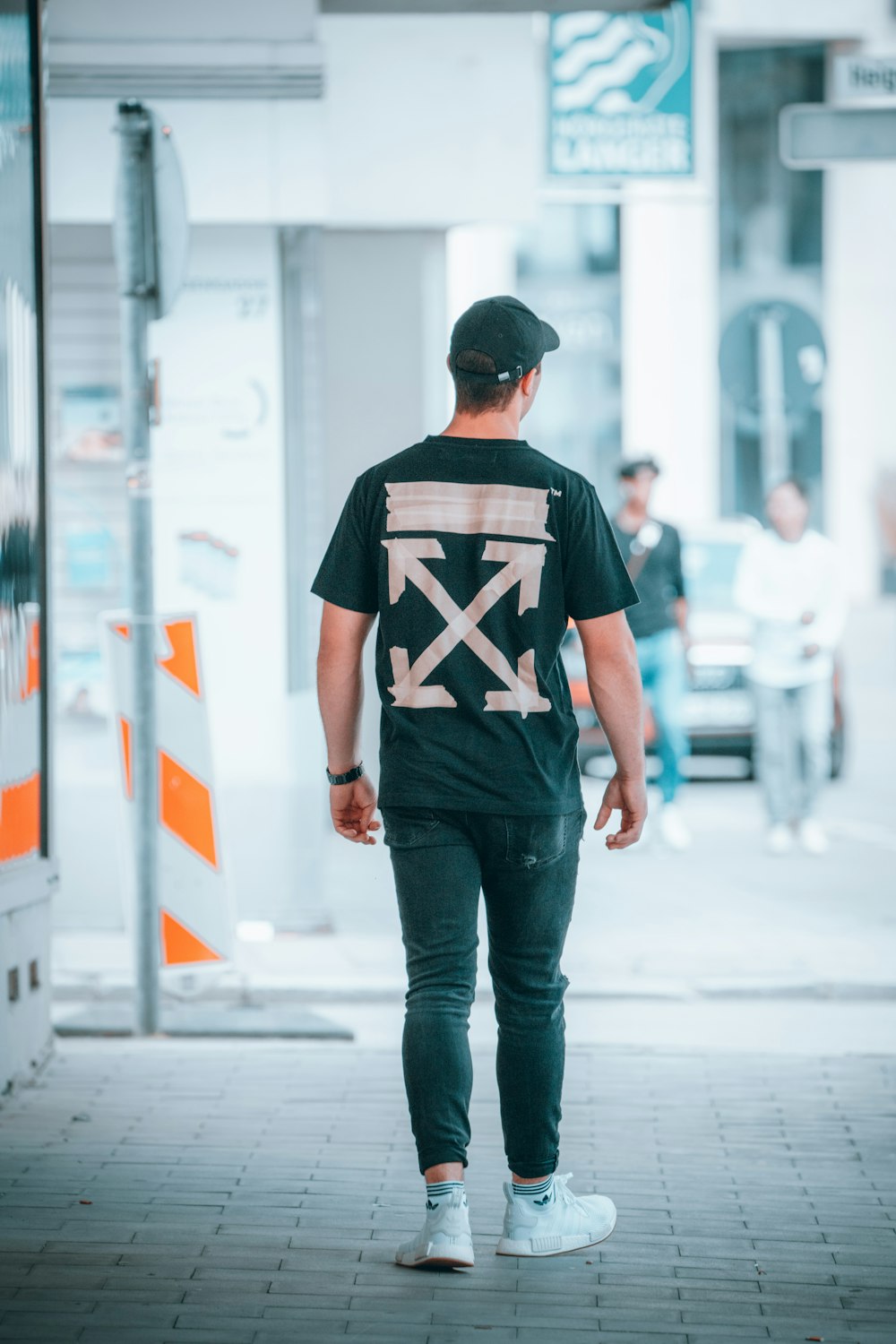 man in black and white star print crew neck t-shirt and blue denim jeans standing