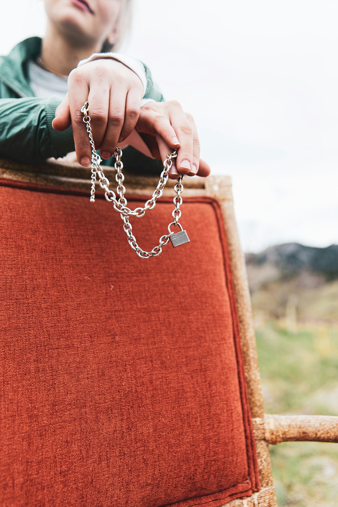 person holding silver chain link necklace