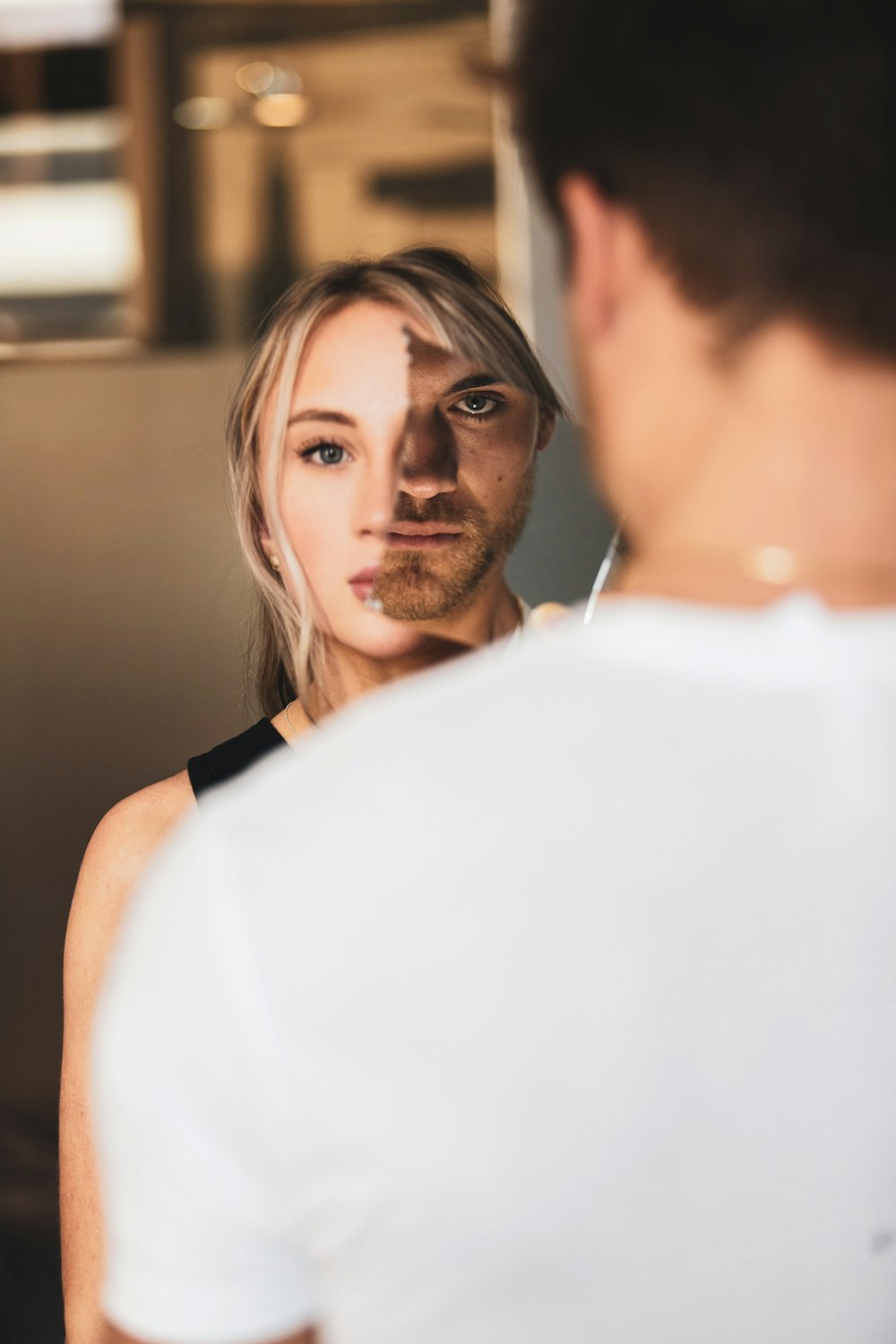 man in white shirt standing beside woman in white sleeveless dress