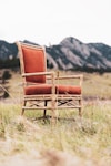 brown wooden armchair on green grass field during daytime