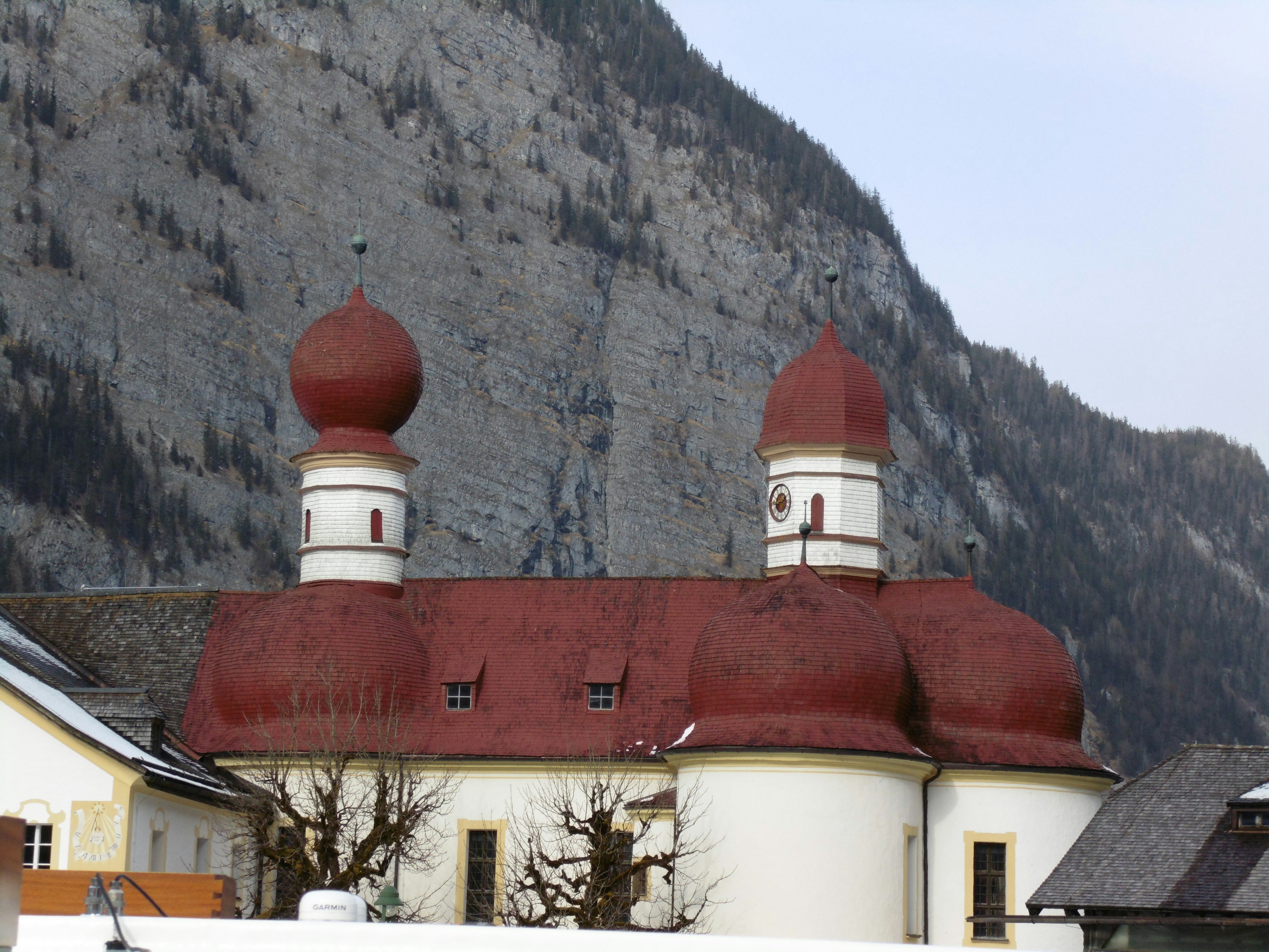 white and red concrete building near mountain during daytime