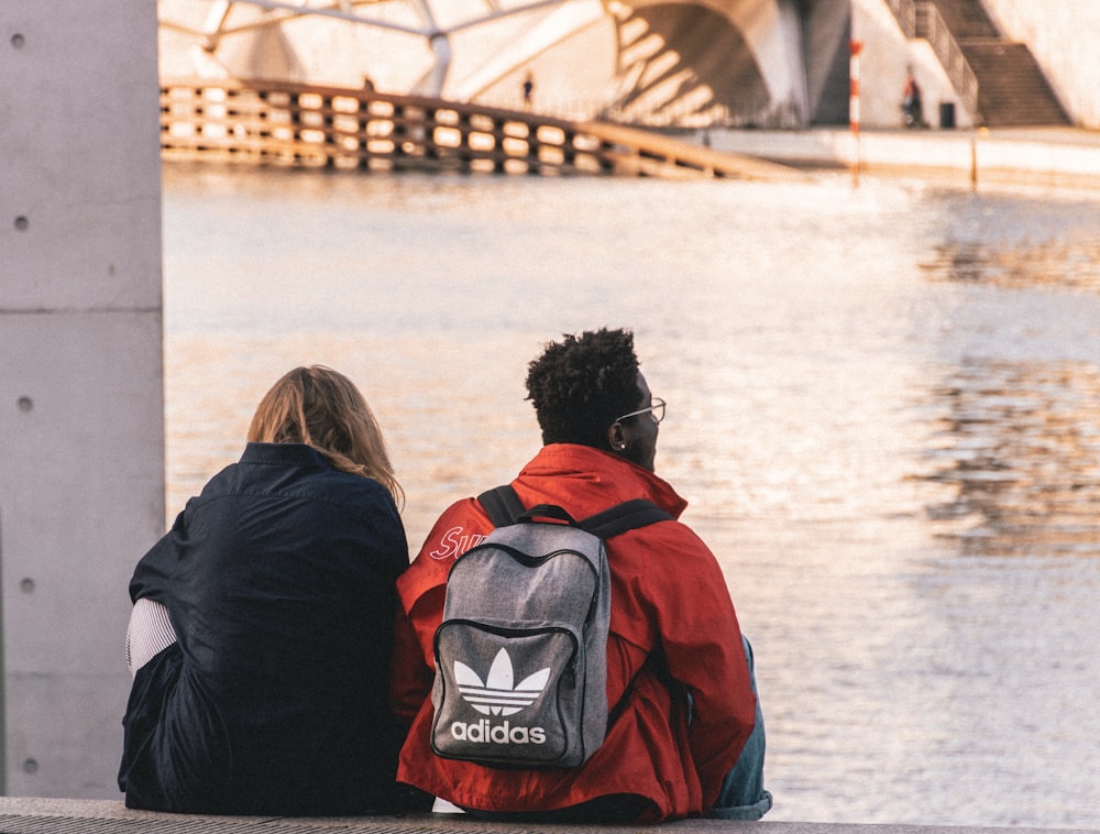 man and woman wearing black and red backpacks