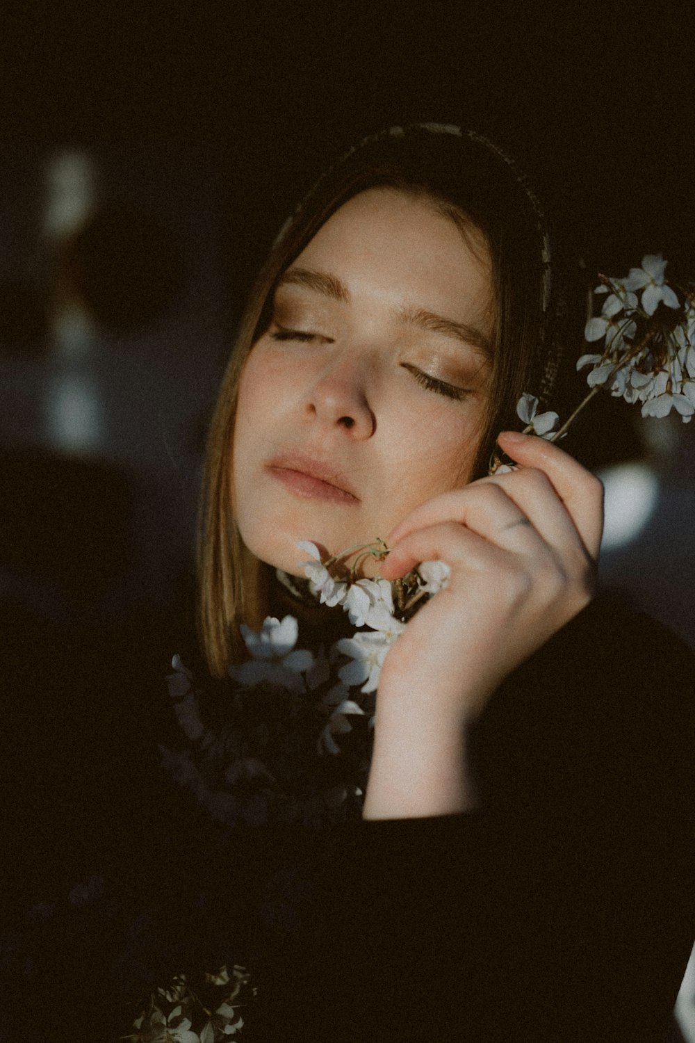 woman in black shirt holding white flowers