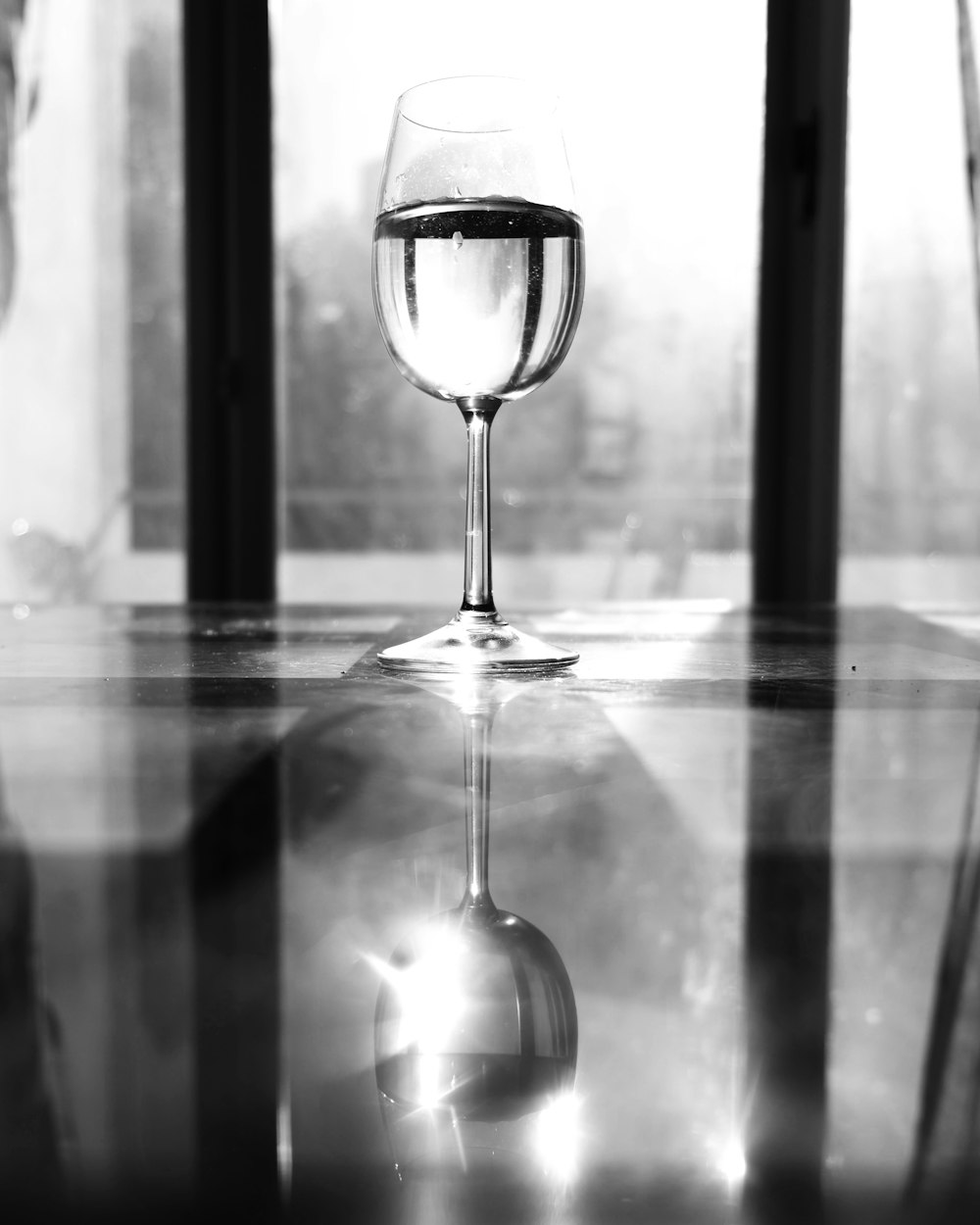 foto in scala di grigi del bicchiere di vino